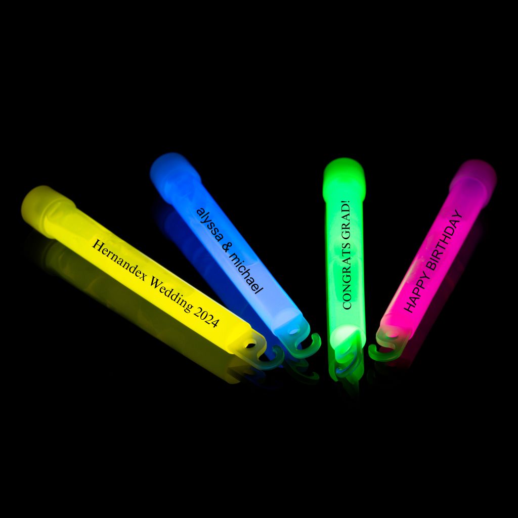 a group of four neon colored pens sitting on top of a black surface