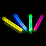 a group of four neon colored pens sitting on top of a black surface